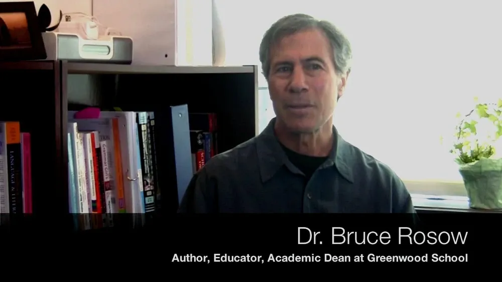 Dr. Bruce Rosow, author, educator, and academic dean, stands in front of a bookshelf.