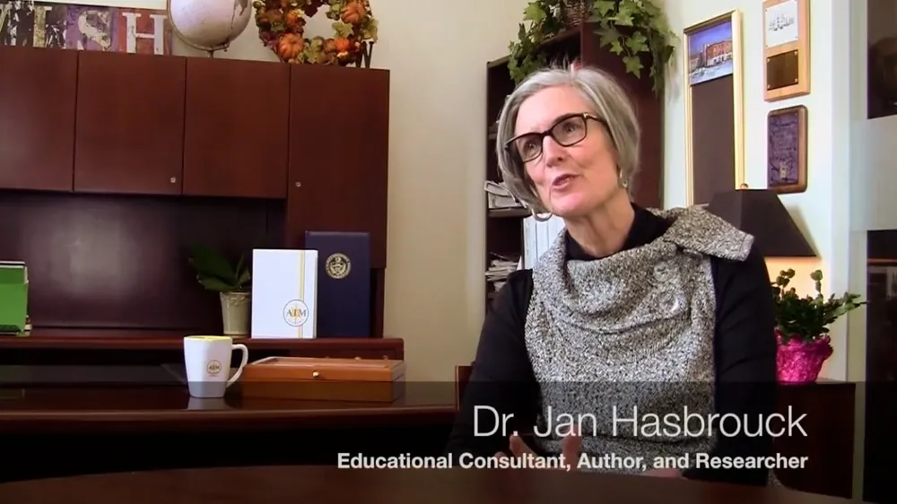 Dr. Jan Hasbrouck, an educational consultant, author, and researcher, speaks while seated at a desk.