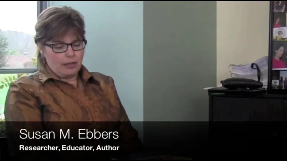 Susan M. Ebbers, a researcher, educator, and author, wears glasses and a brown shirt.